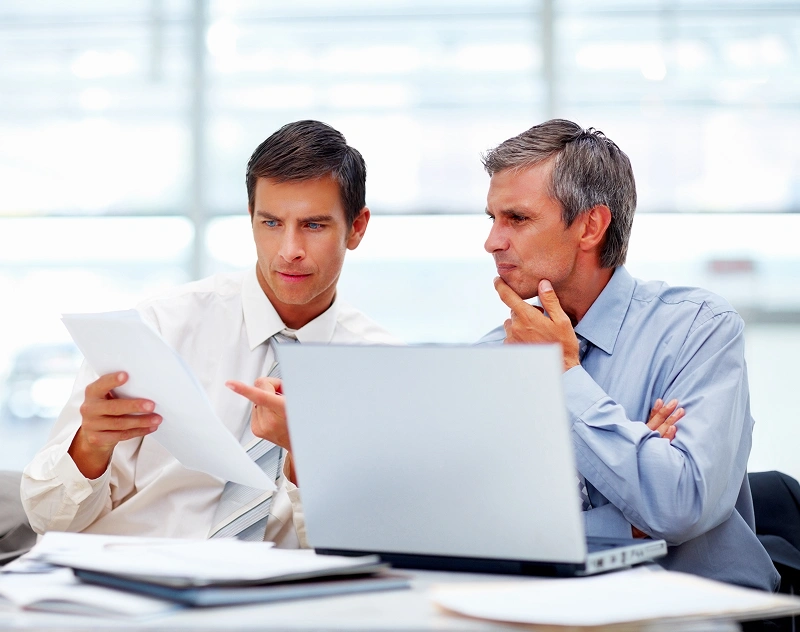 Professionals analyzing paperwork in office setting